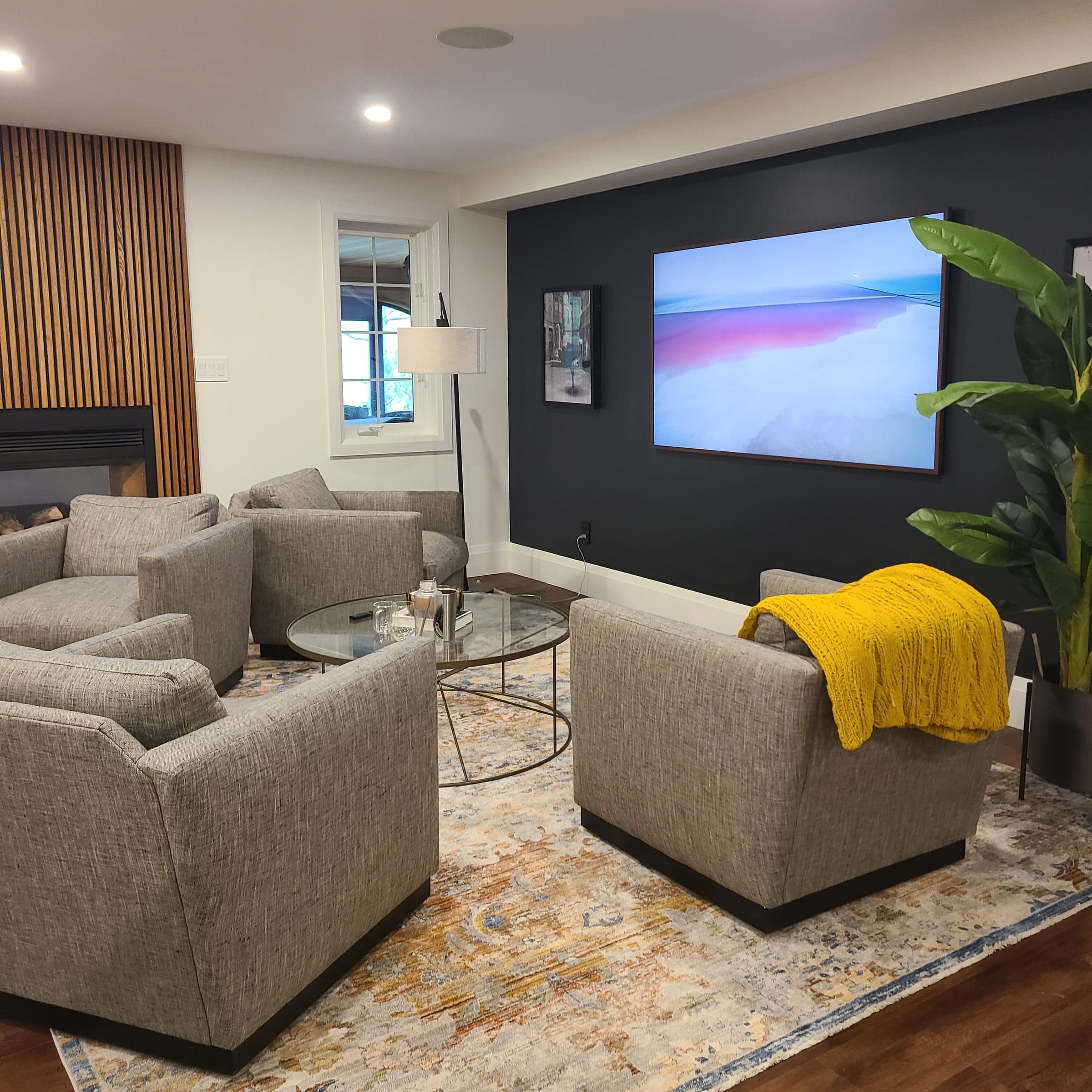 Finished lower-level media room with seating, television, and built-in storage