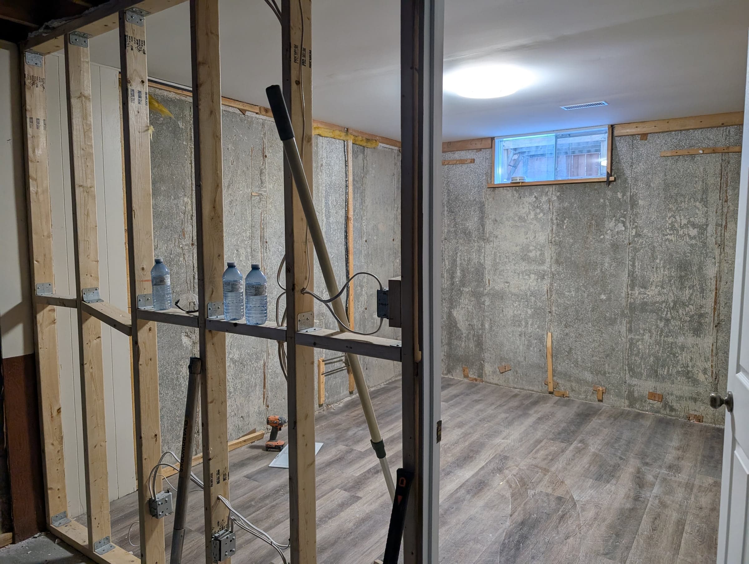 Basement under construction with open timber framing and concrete walls
