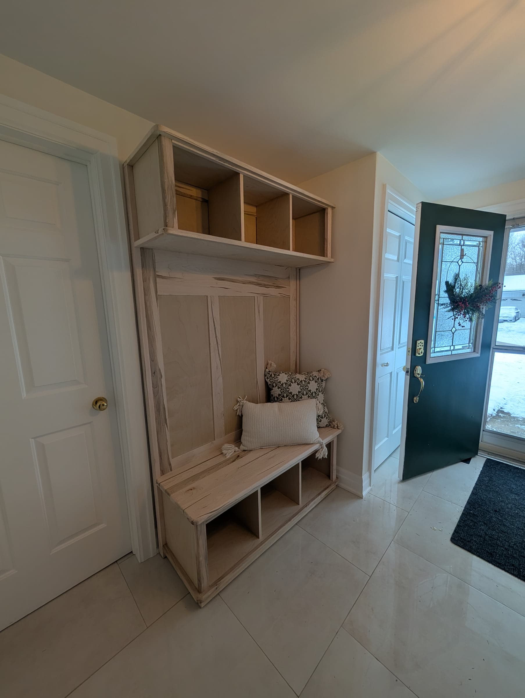 Tall mudroom storage unit with bench, hooks, shelves, and drawers