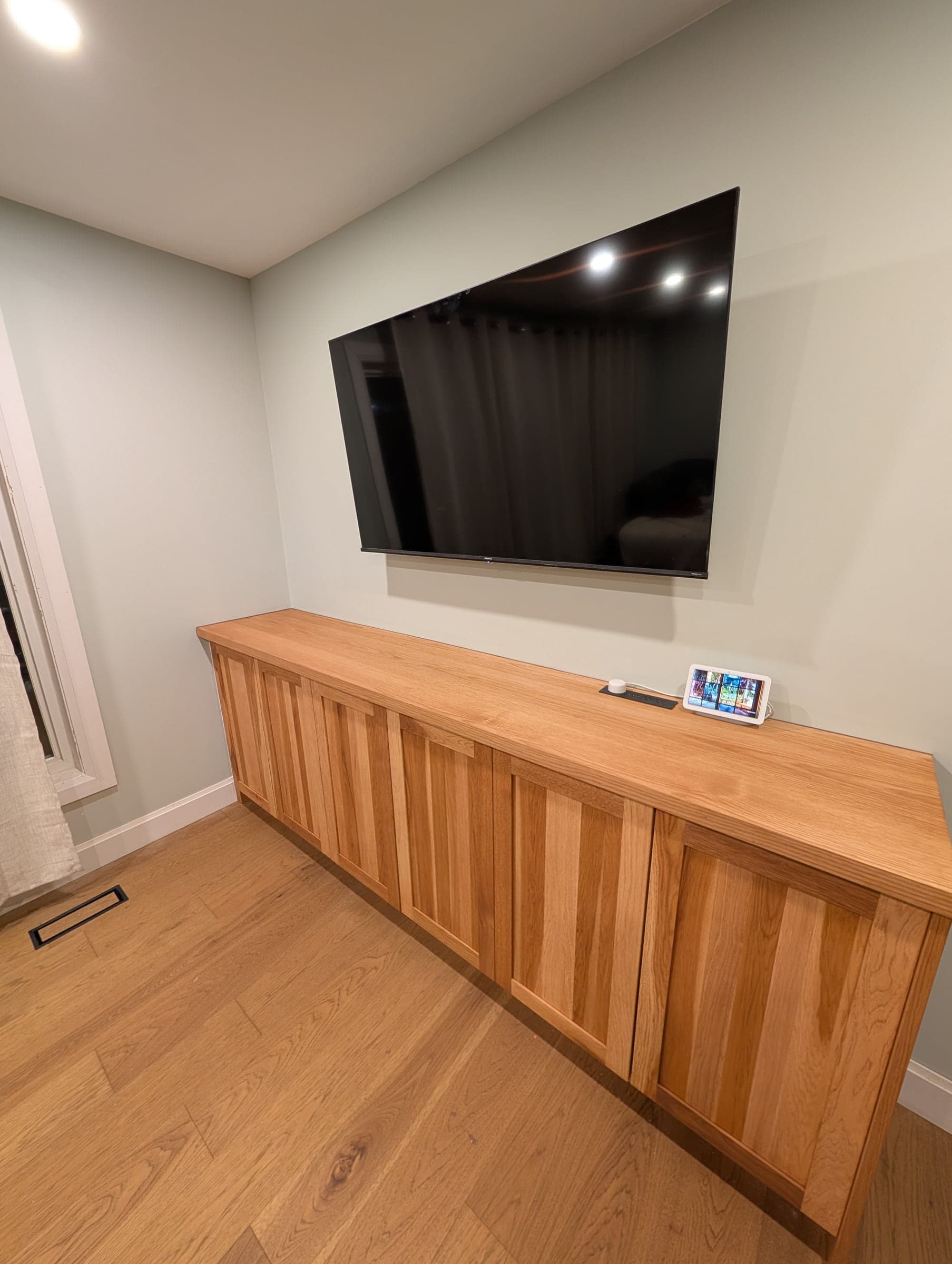 Wood media cabinet with drawers, open shelving, and a television