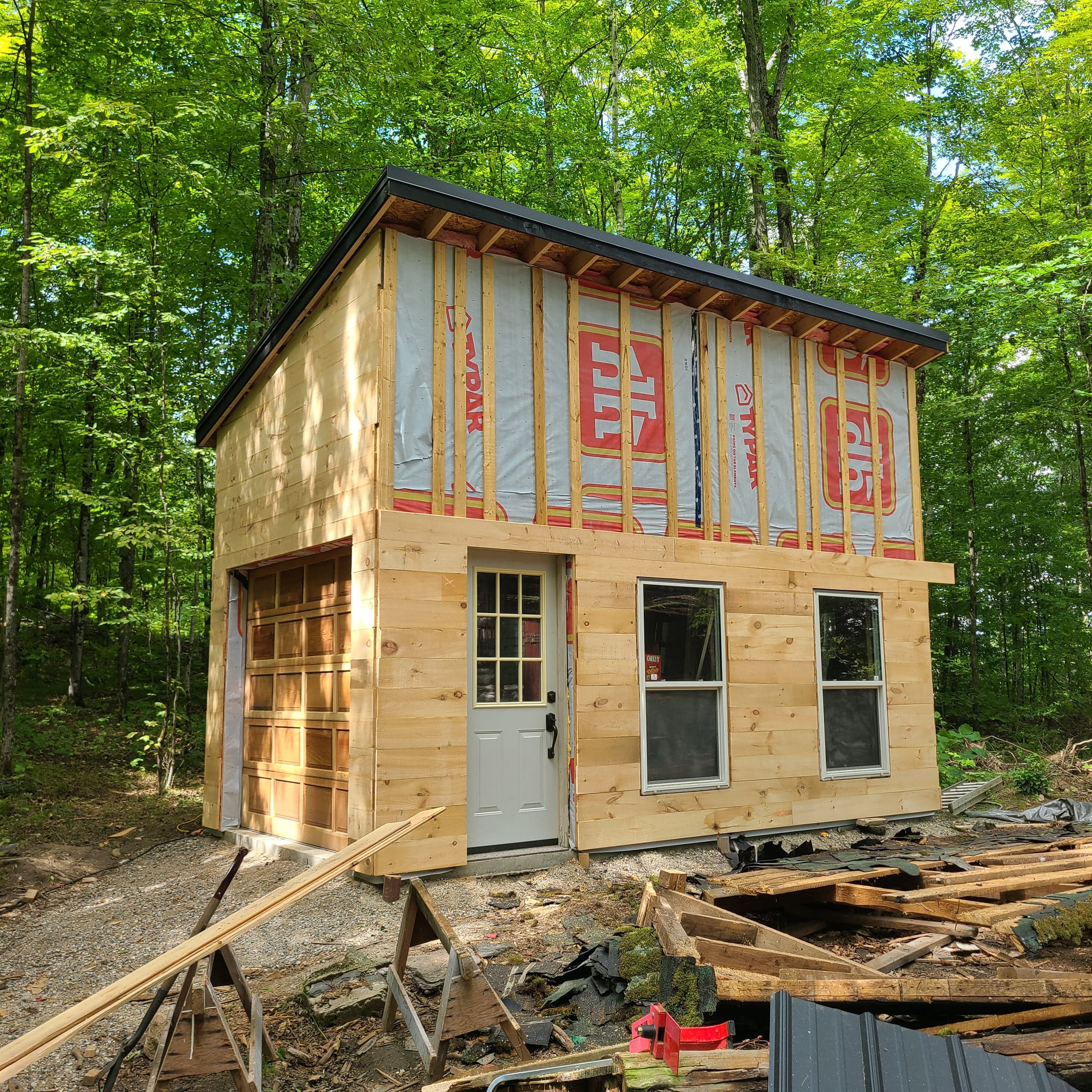 Outbuilding under construction with wrapped wall sheathing and roof framing