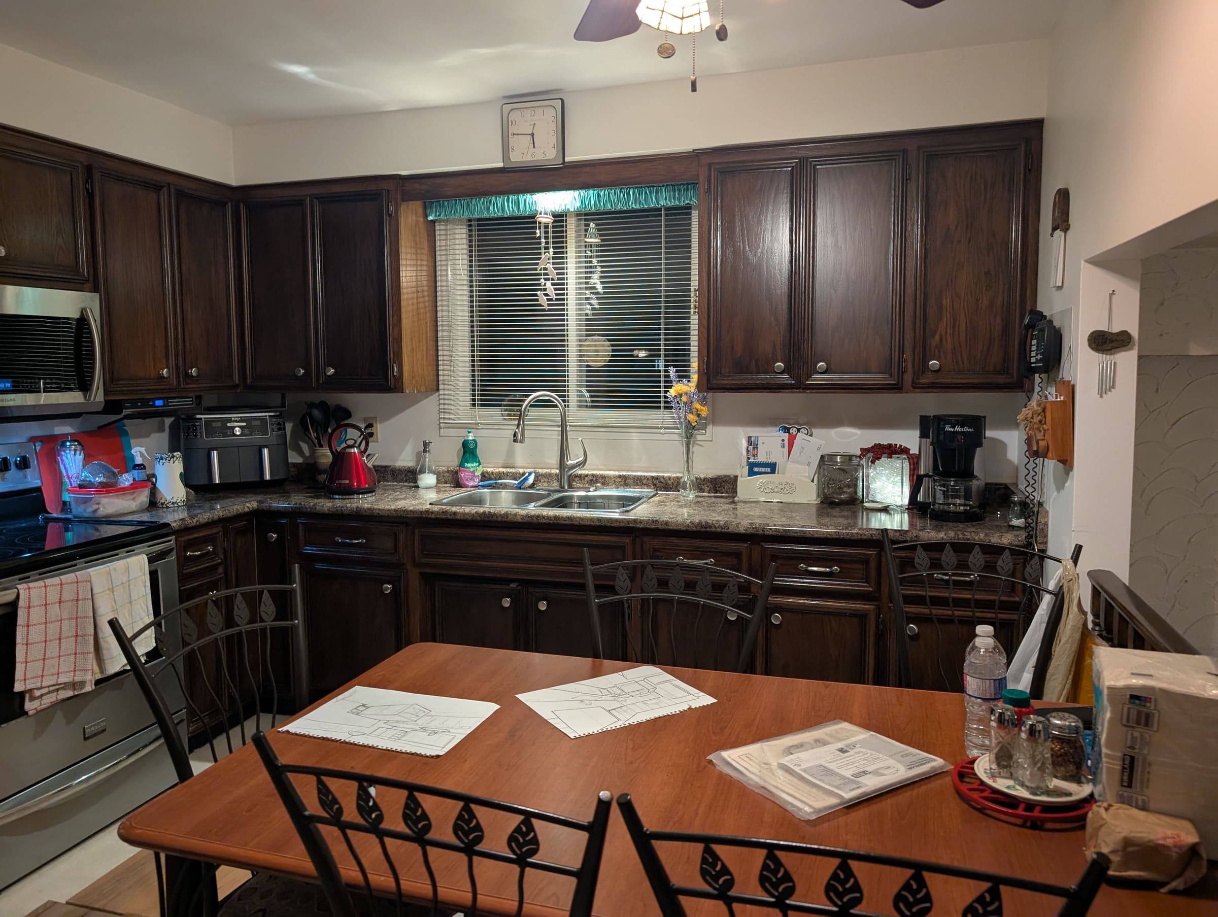Kitchen before renovation with dark wood cabinetry and a central island