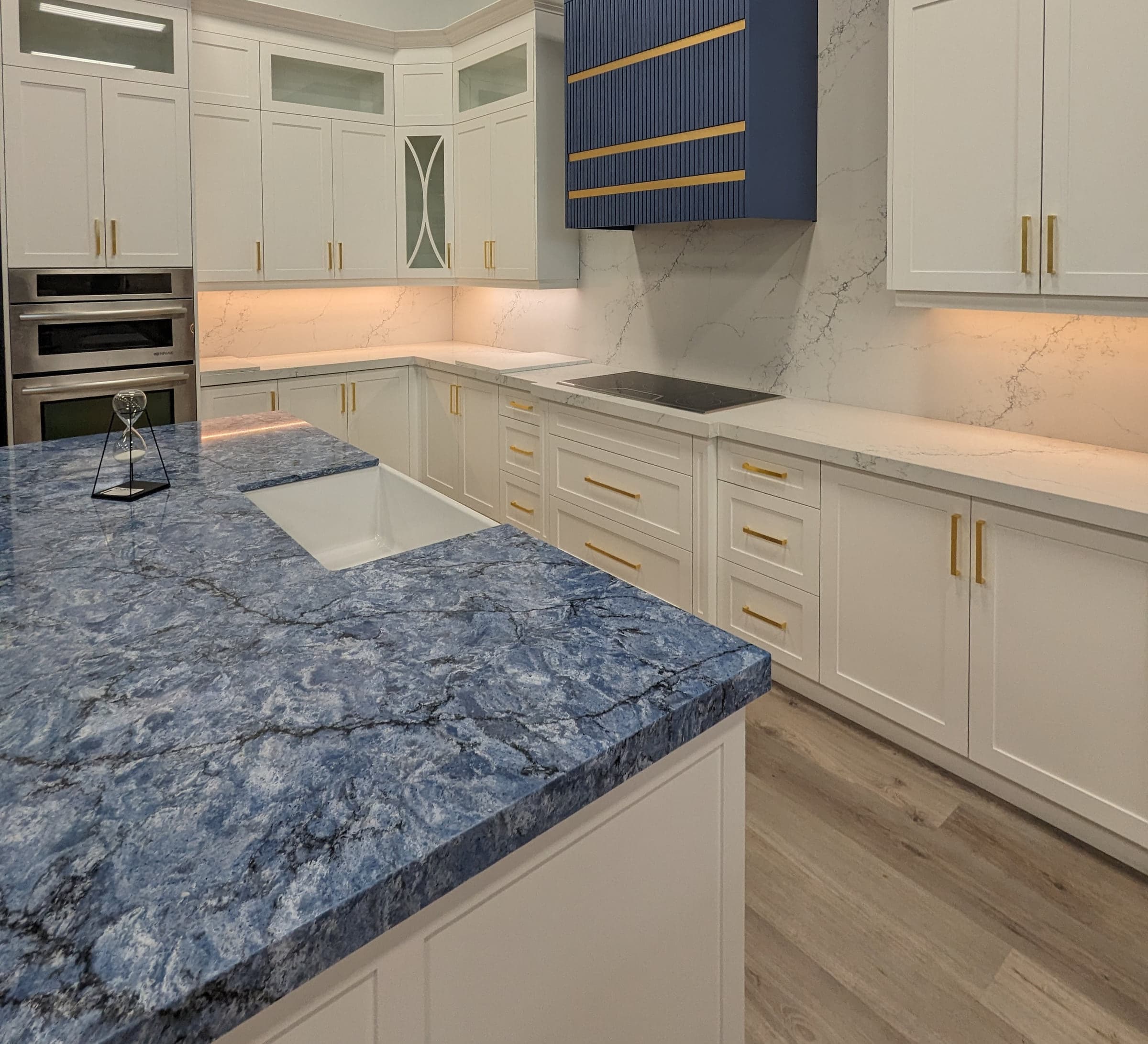 White cabinetry beside a blue-grey stone countertop