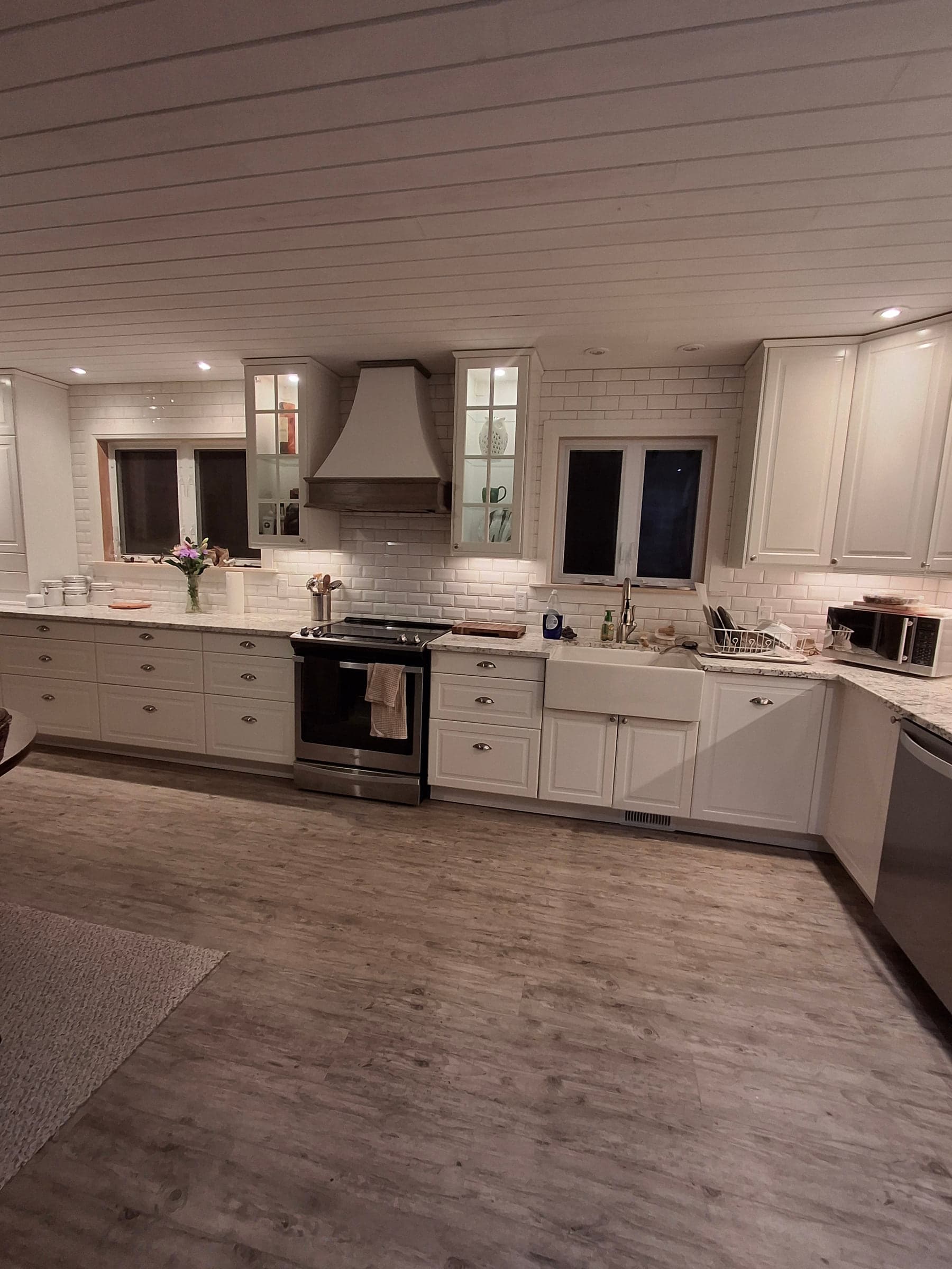 Finished white kitchen with cabinetry, range, and patterned backsplash
