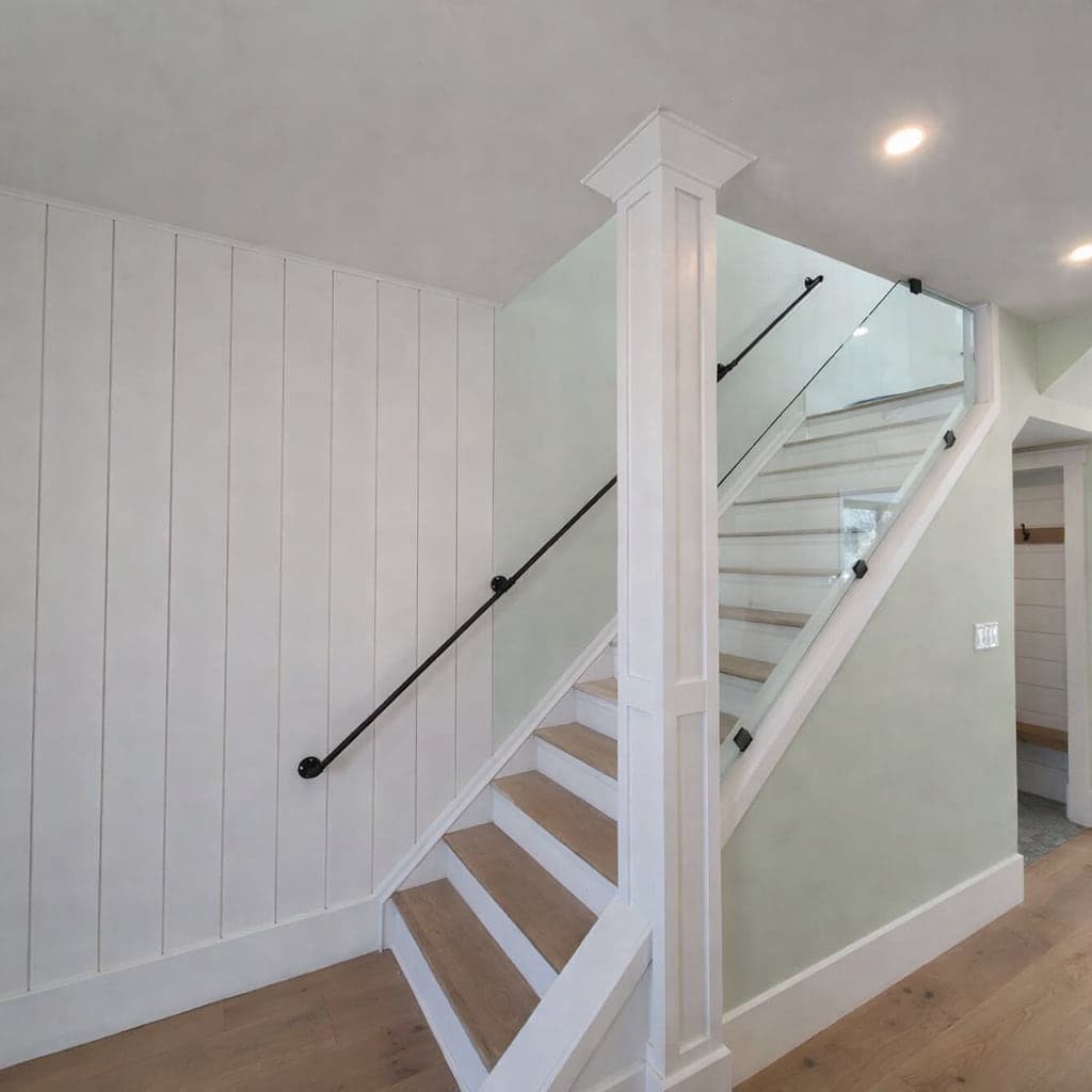 Finished white staircase with dark handrail and balusters