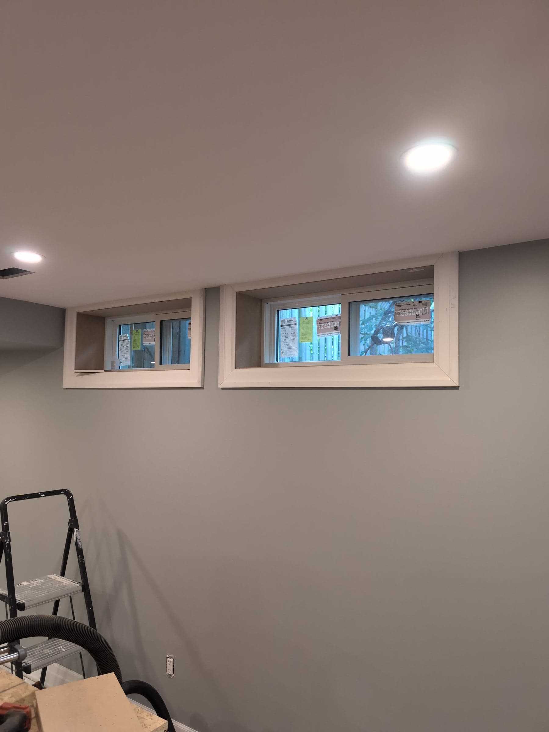 Group of finished basement windows set into a light wall